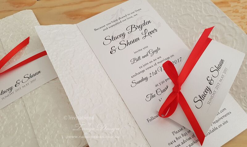 white embossed floral wedding invites with red ribbon