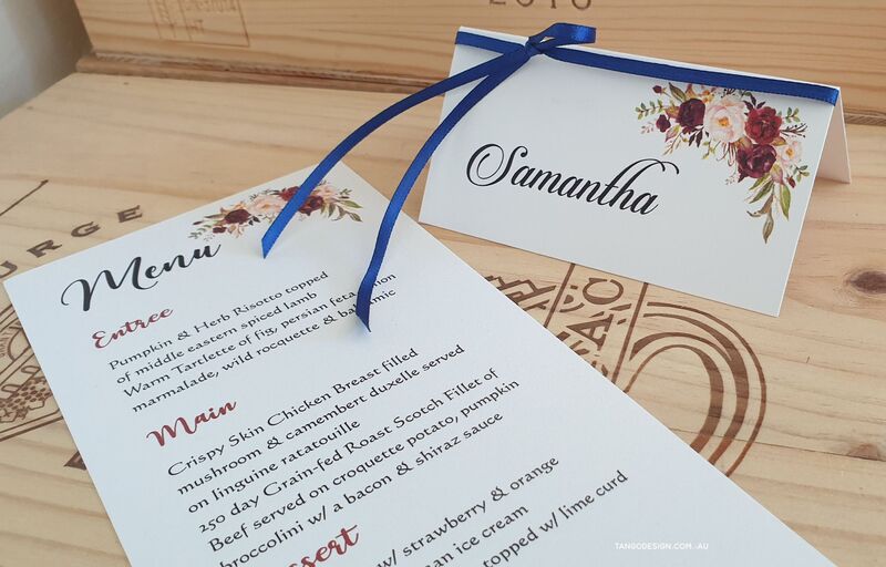 burgundy and blue floral wedding stationery. Burgundy menu and name tags with blue ribbon. Tango design.